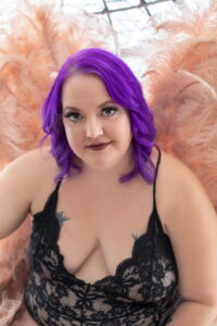 Woman with purple hair wearing pink angel wings