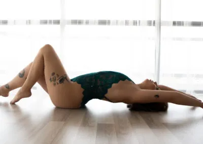 Emerald Green Bodysuit in a boudoir pose that showcases back arch.