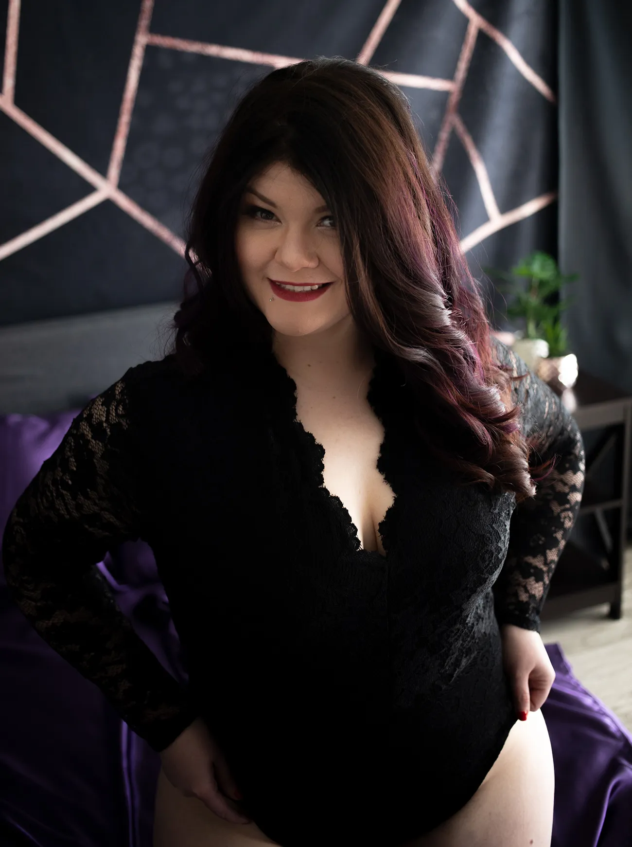 Brunette smiling in Black bodysuit with sleeves